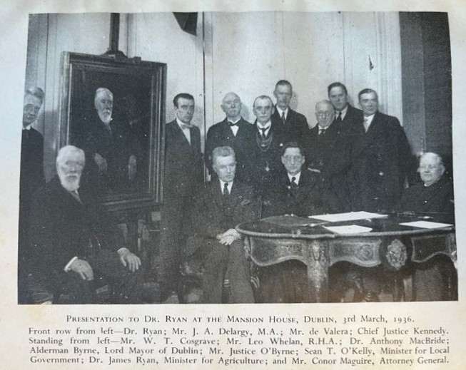 Presentation to Dr Ryan in the Mansion House in Dublin. Ryan is seated next to his portrait, with both WT Cosgrave and Eamon de Valera present.